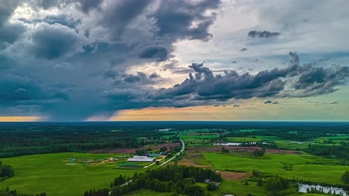 Aerial View Over Vast Green Fields and Cloudy Sky