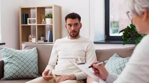 Man Talking to Therapist on Couch in Living Room