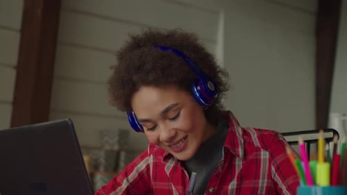 Young Adult Doing Homework While Using a Laptop