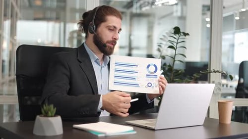 Young Adult in Suit Presents Graph in Office