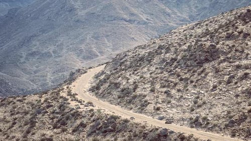 Dusty Winding Road Through Rocky Terrain in a Remote Mountainous Region