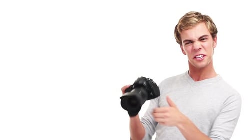 4k video footage of a young male photographer taking videos against a studio background