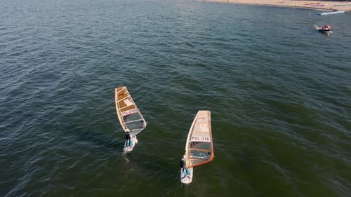 Woman and Man Control the Sail of a Windsurf Board While Sailing Aerial View