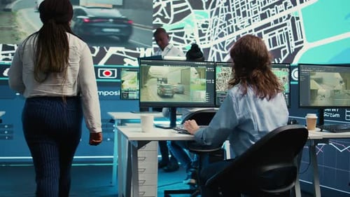 Diverse Team of Employees Monitoring Delivery Trucks Routes Around the City