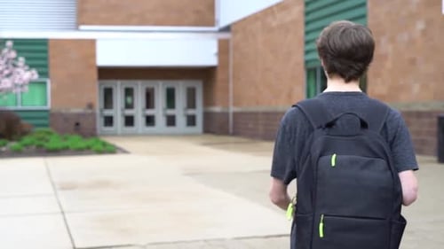 Shot of male student entering high school in Pinckney, Michigan.