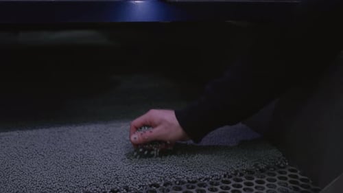 Hand Touches the Microplastic Granules From the Extruder Plastic or Polypropylene Pellets