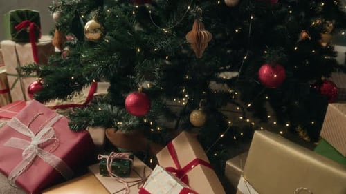 Stapel von Geschenkboxen, eingewickelt in buntes Papier, liegen zu Hause unter dem Weihnachtsbaum