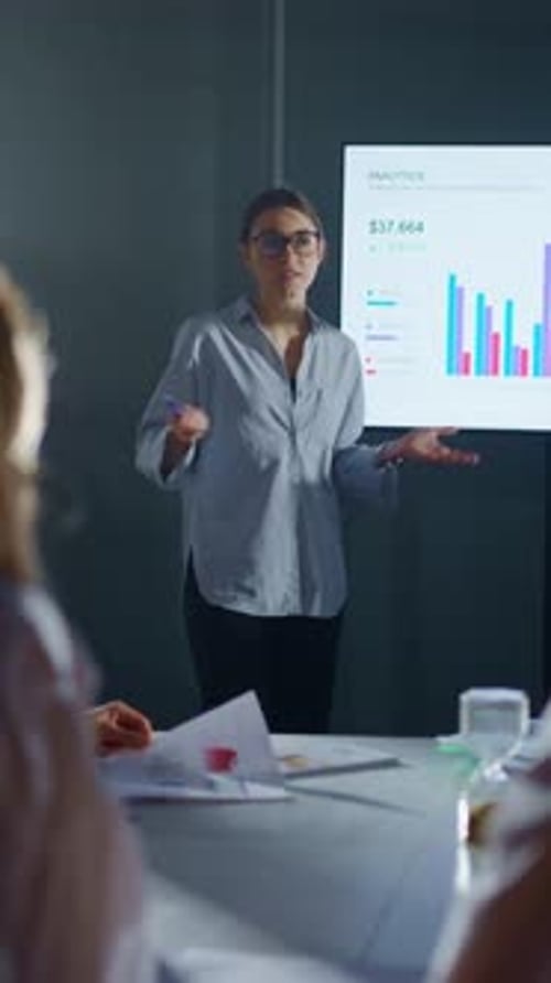 Business Analyst Presenting Colorful Financial Charts on Digital Screen During Modern Office Meeting