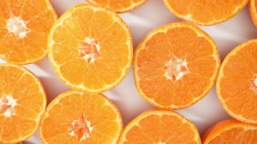 Orange Halves Sit On White Surface
