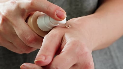 Junge Frau checkt bei der Auswahl von Handpflegecreme im Kosmetik-Supermarkt Ton- oder Lippenstiftkontrolle