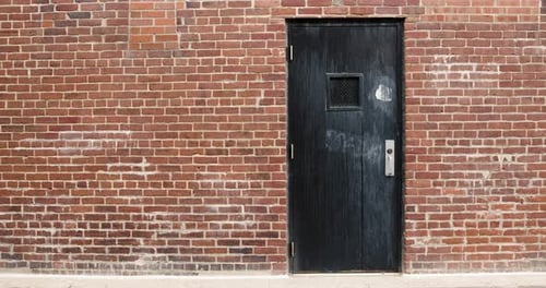 Black Wooden Door in Brick Alley