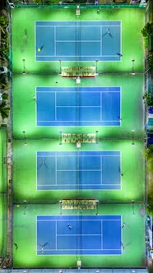 Illuminated Tennis Courts at Night from Aerial View