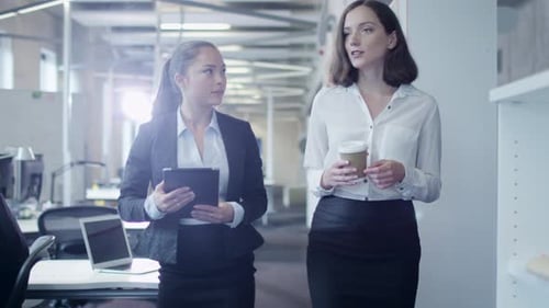 Two Attractive Female Workers are Walking through Office.