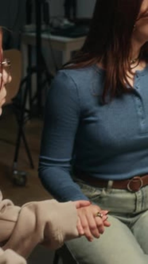 Vertical of Young Female Counselor Holding Hands during Support Group Therapy