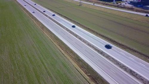 Freeway Road with Moving Cars Between Green Fields