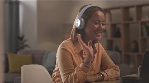 Woman Using Laptop and Headphones at Home