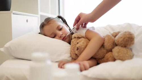 Close Up of Mother Using Thermometer to Sick Little Girl