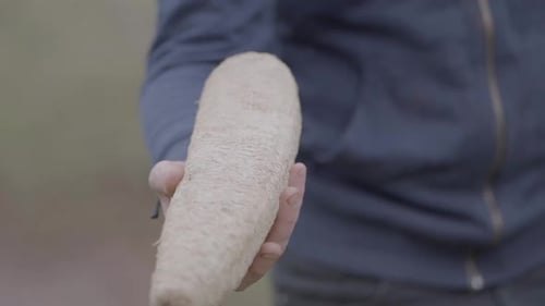 Man holding a sponge loofah in a rural area of South America.