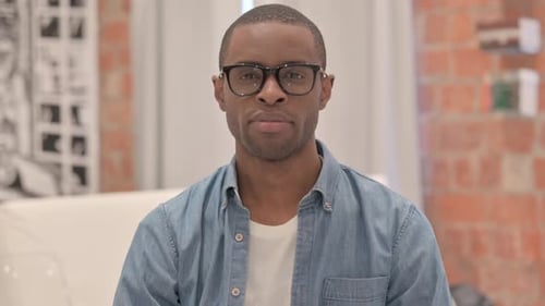 Man with Glasses Stares Intently Indoors