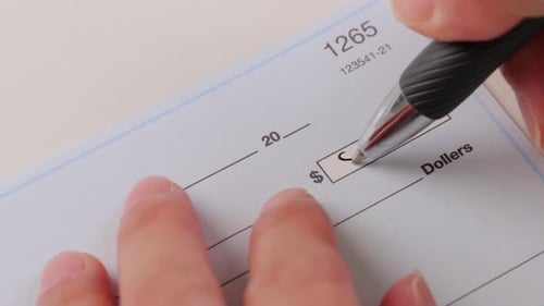 Close-up Shot Of A Hand Writing A Check