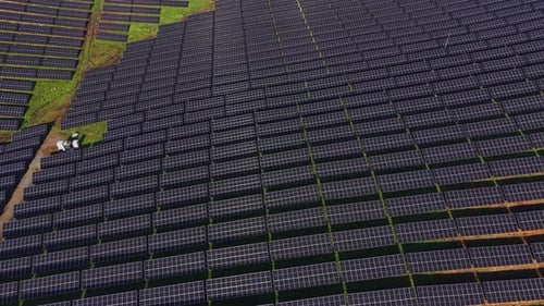 Solar panels cover large area on sunny day with organized layout