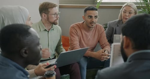 Multiethnic Group of Coworkers Talking Discussing Work Explaining Business Solutions in Office