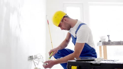 Electrician fixing wires in a new home
