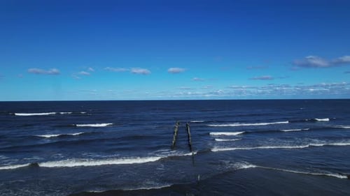 A wooden post sticking out of the ocean
