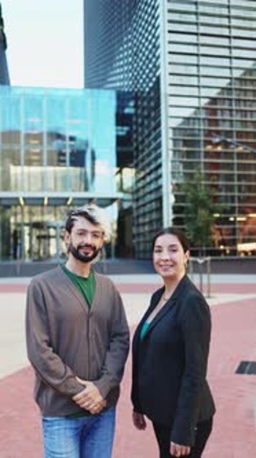 Portrait of two business colleagues smiling at the camera while crossing their arms