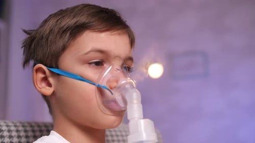Child with Oxygen Mask Inhalation Treatment Close Up