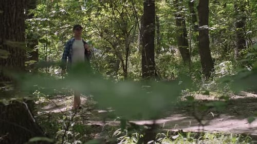 A man with a backpack exercises in the forest, outdoor fitness featuring active hiking with a backpa