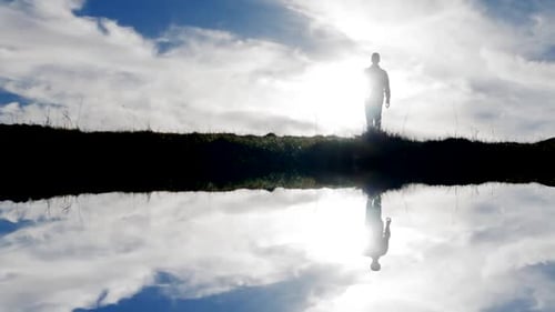 Silhouette of Man Walking in Nature Landscape Hiking with Cloudscape Sky