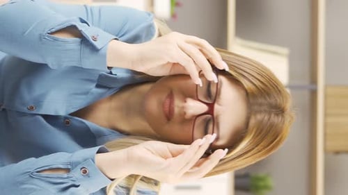 Stressed Woman with Headache Removes Eyeglasses Indoors