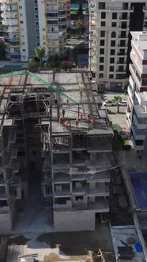 Vertical Video Concrete Being Poured for a Highrise Residential Foundation on a Busy Construction