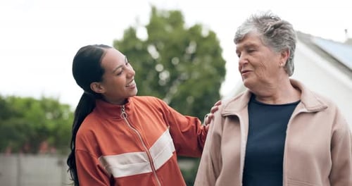 Young Woman Assists Senior Woman with Exercise
