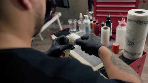 Tattoo Artist Prepares Equipment in Studio Setting