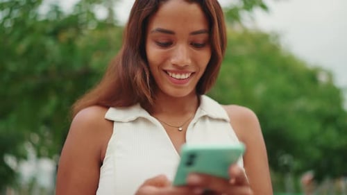 Smiling Woman Using Mobile Phone in Urban Setting