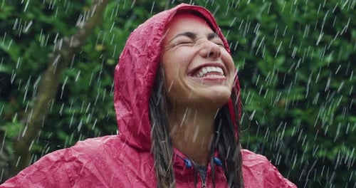 Woman Laughs in Rain Wearing Red Raincoat