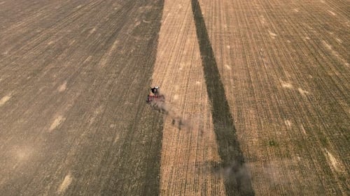 Tractor with Plow Preparing Land for Sowing in Farm Field