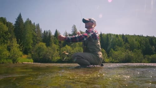 Fly fishing. Man fishing on the river on fly. Male caucasian angler fishing