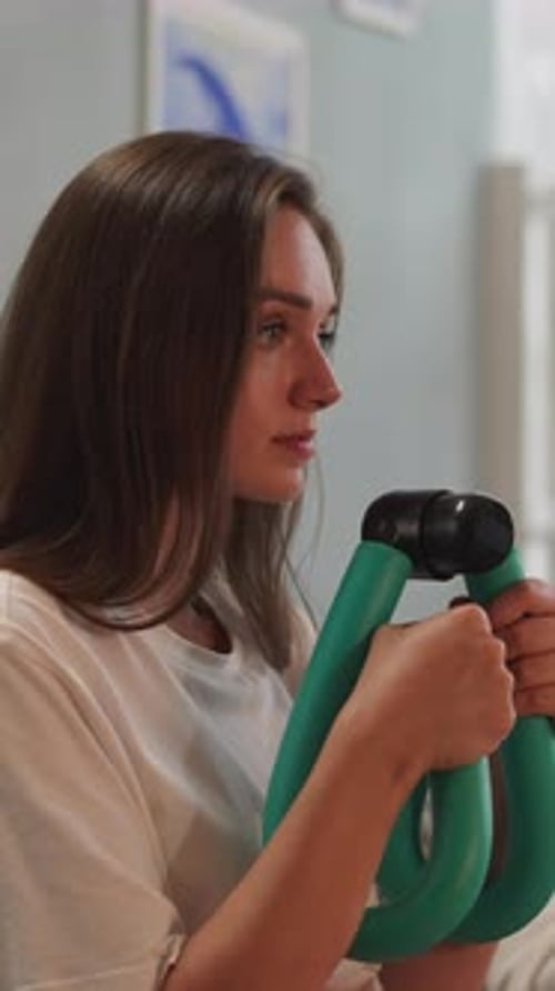 Une femme renforce les muscles des bras en poussant un appareil d'entraînement