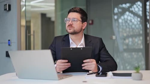 Business Professional Thoughtfully Reviews Documents