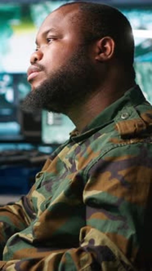 Man in Camouflage Uniform at Computer Workstation