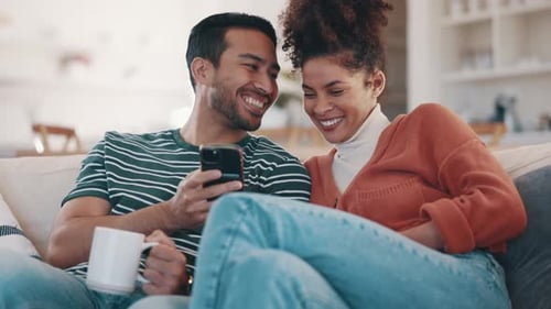 Joyful Couple Watching Smartphone at Home Together