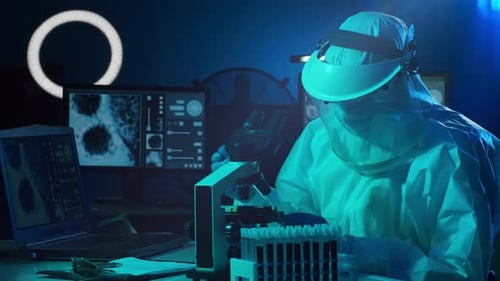 Scientist Works with Microscope and Test Tubes in Lab