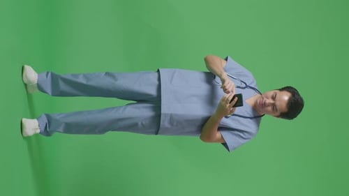 Full Body Of Asian Male Doctor With Stethoscope Using Smartphone On Green Screen Background