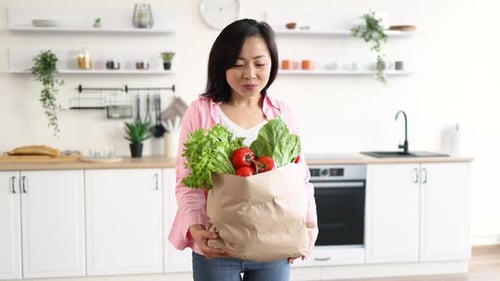 Woman with Groceries in Kitchen