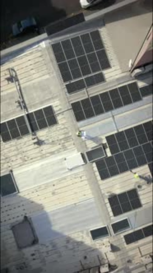 Drone, rooftop and people with solar panels, city and blueprint for property development
