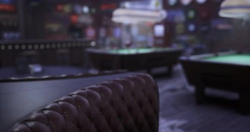 Interior of a Busy Pool Hall with Dim Lighting and Green Tables
