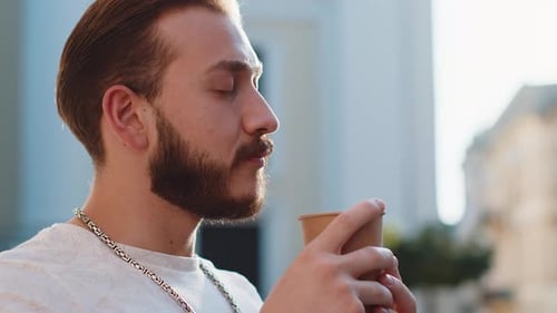 Young Man Guy Enjoying Drinking Morning Coffee Hot Drink Relaxing Taking a Break in City Street
